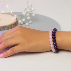 Woman’s hand wearing Rose Quartz and Amethyst love healing crystal bracelets for relationship and marriage